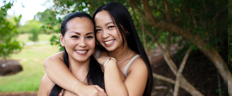 mother and daughter standing closely together and smiling