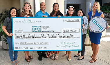 group of health care employees holding a giant check