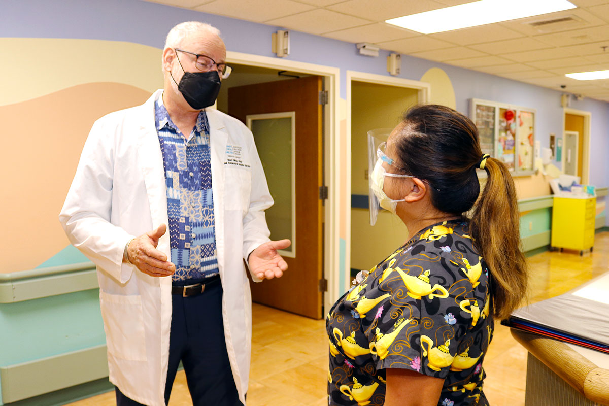 A doctor talks with a colleague in a hallway.