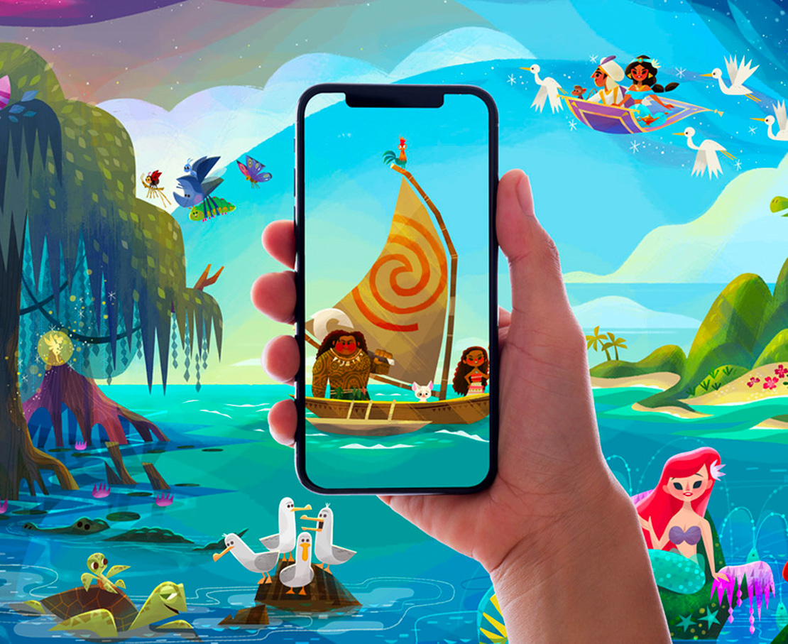 Hand holding smartphone device showing characters from the animated film Moana, surrounded by characters from other Disney films that may show in the app.