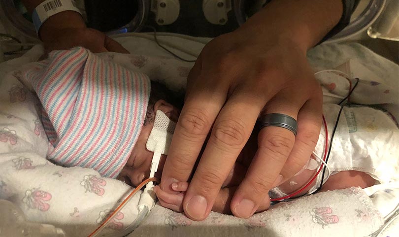 Micropreemie with a caring band covering nearly er entire body.
