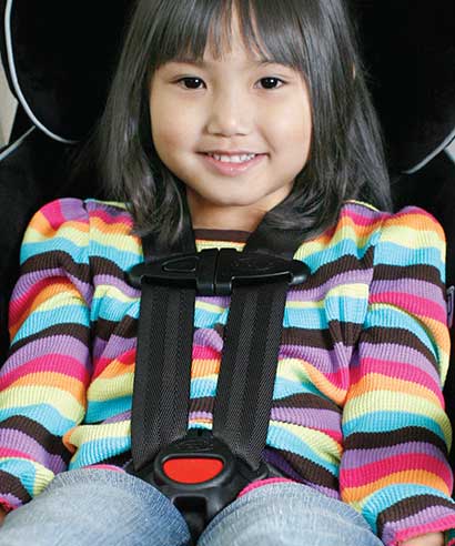 Smiling young girl in car seat.