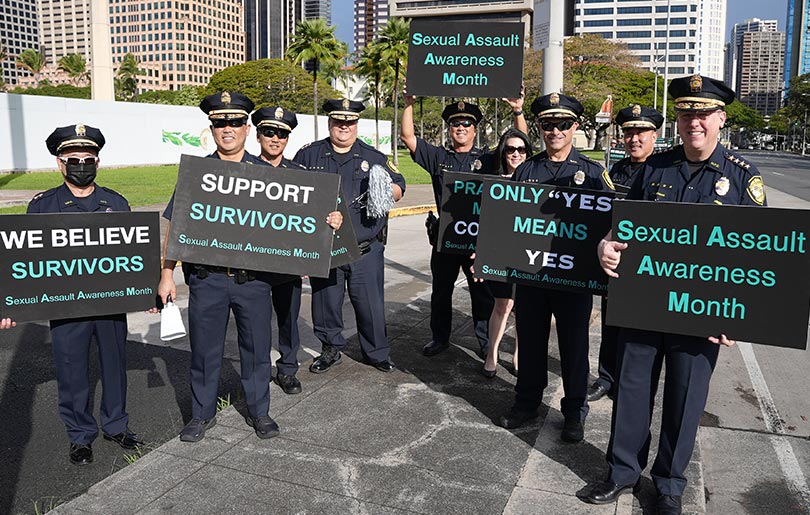 Honolulu Police Department officers holding signs in support of survivors of sexual assault