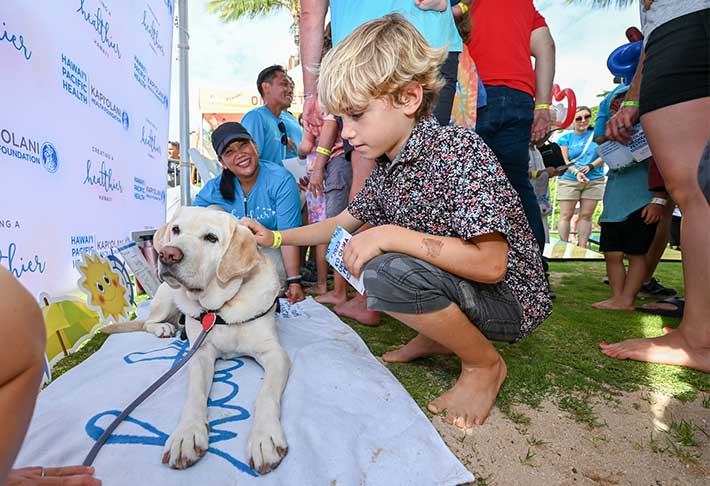 Boy calmly petting support dog.