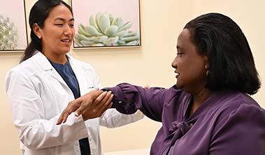 female orthopedic doctor examines a female patient's arm
