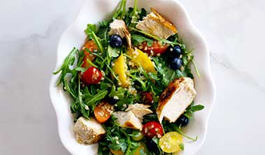 Colorful salad with chicken and fruit.