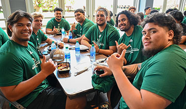 Seated group of Hawaii football players.