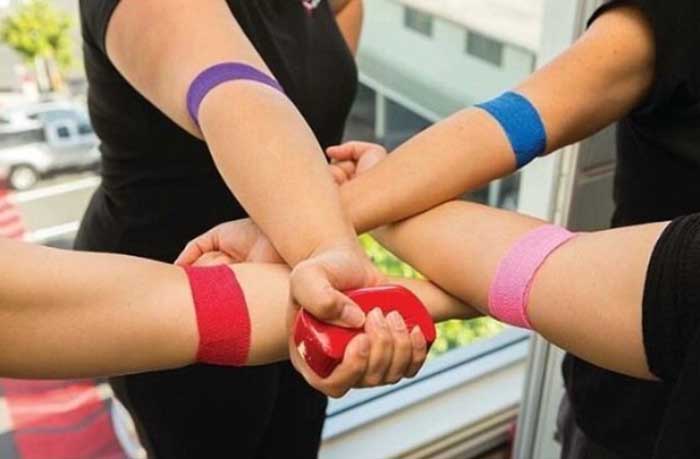 arms of blood donors with colorful bandages