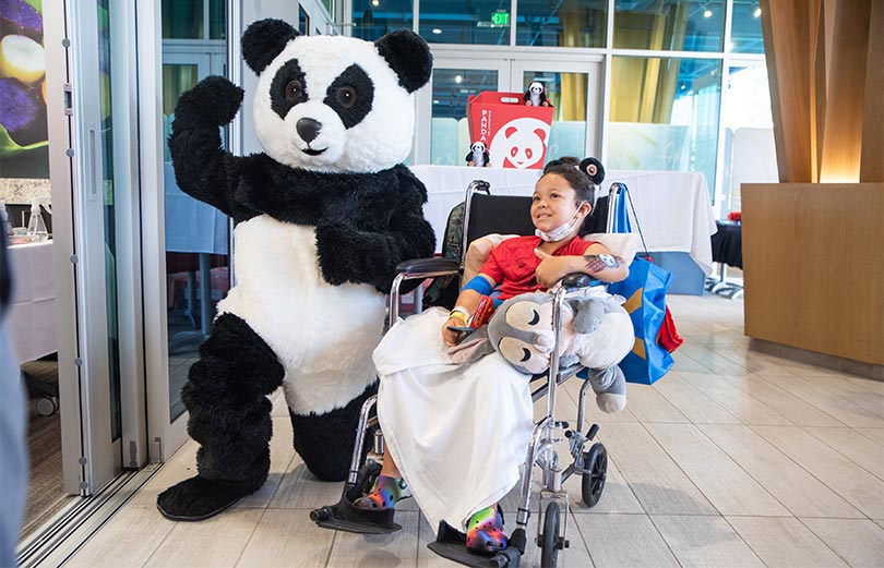 Giant panda with smiling child patient.