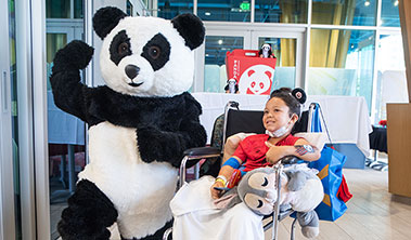Giant panda with smiling child patient.