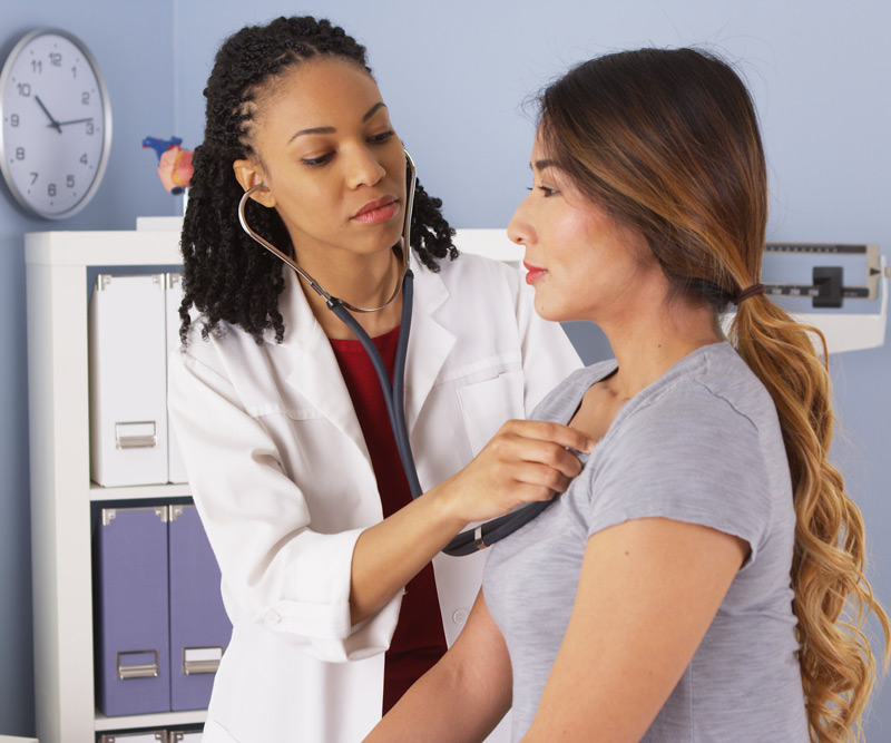 woman getting her heart examined by doctor