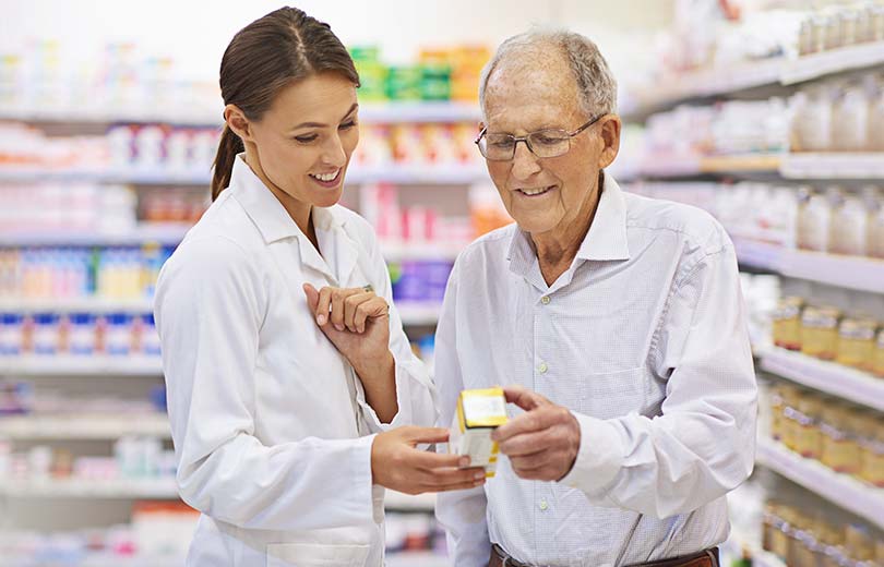 Pharmacist with older man discussing his medication.