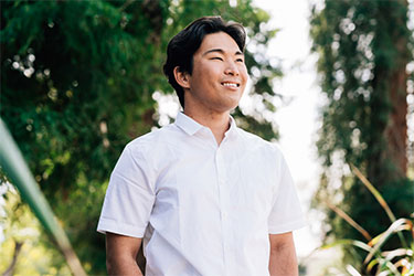 Young healthy man smiling and looking into distance.