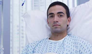 Serious faced young man in a hospital bed.