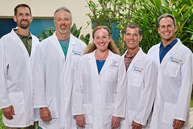 Group shot of five physicians in white coats.