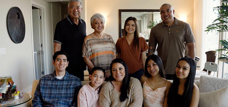 Group shot of smiling family in their home.