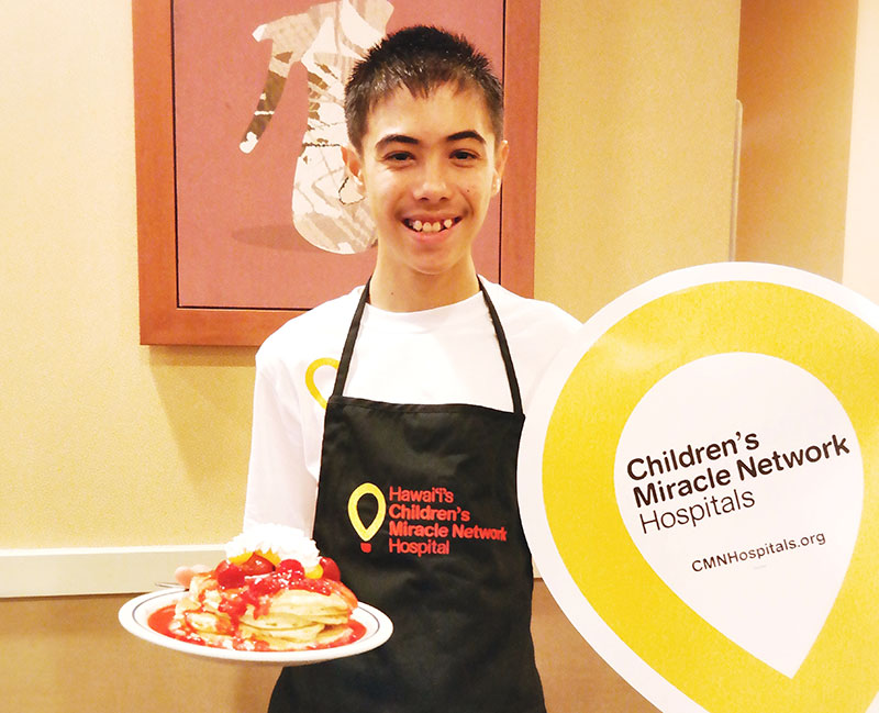 a staff holding a plate full of pancakes