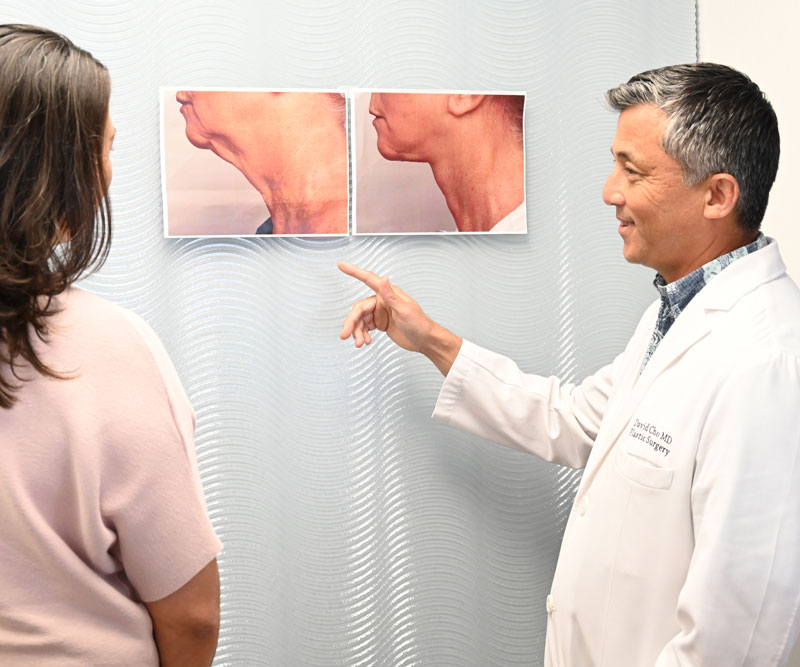 a plastic surgeon and department supervisor look at before-and-after photos of a patient's facelift