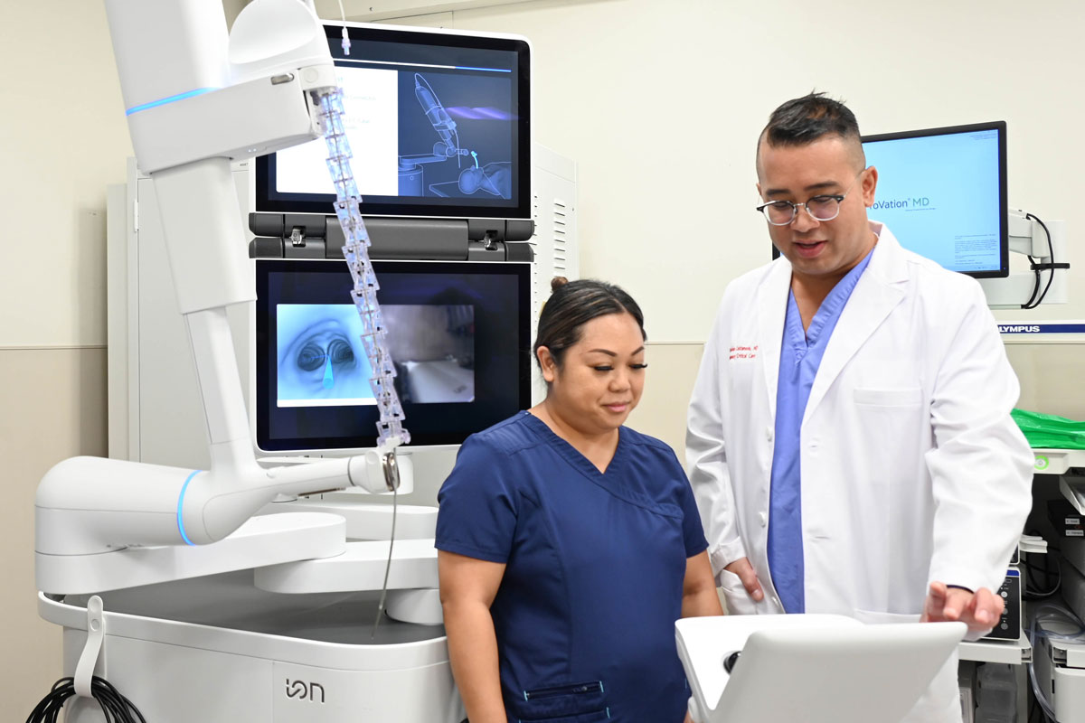 a doctor and nurse look at a monitor in a lung cancer screening room