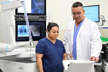 medical professionals in a clinic looking at a medical instrument monitor.