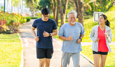 young couple walks along a path outdoors with elderly father