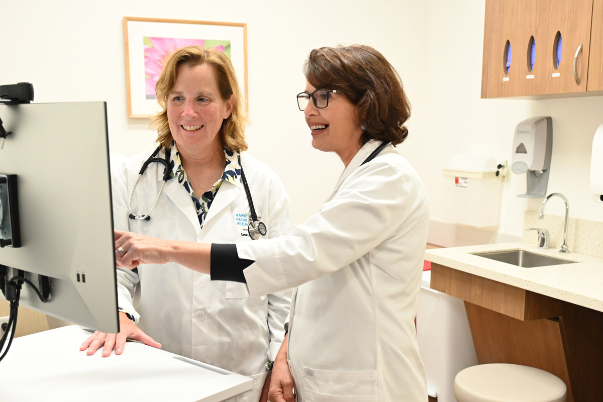 a female doctor and female physician assistant look at a computer in a clinic room at the Straub Benioff Mililani Clinic