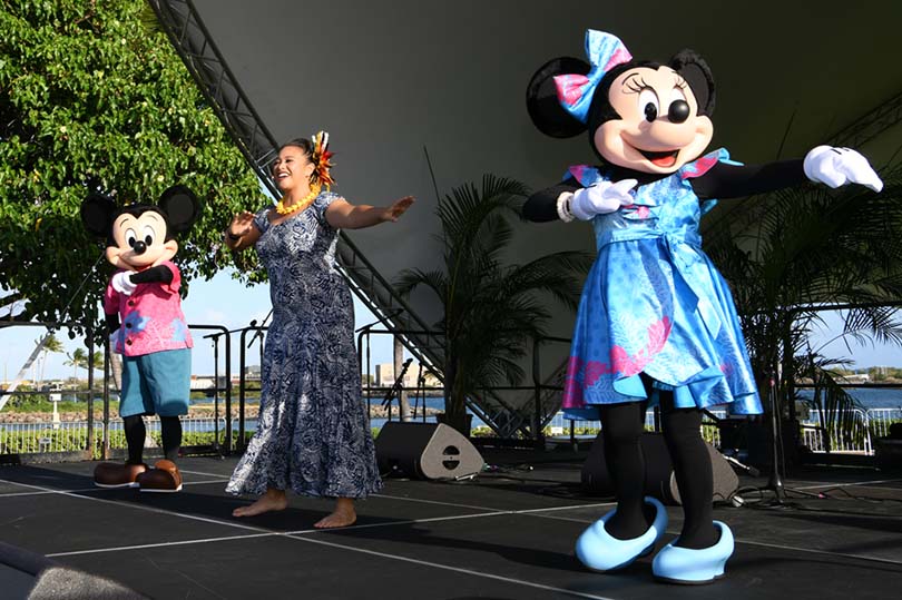 Minnie Mouse, Mickey Mouse with hula dancer dancing on stage.