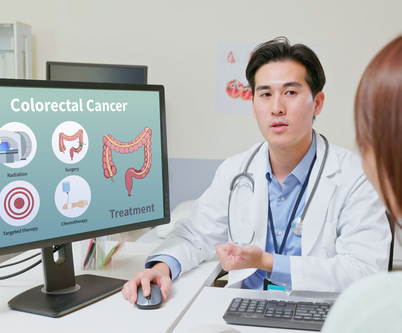 a doctor talks with a young female patient about colorectal screening in an exam room