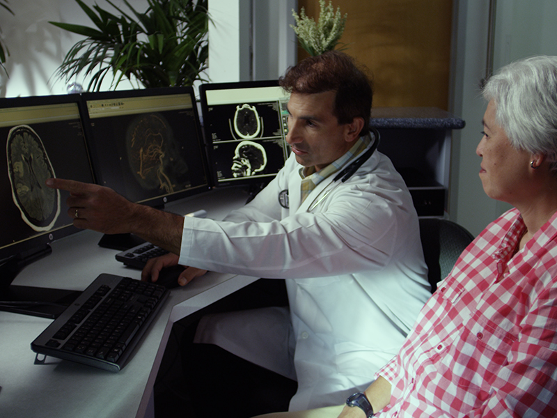 a doctor talking to a patient pointing to a computer screen