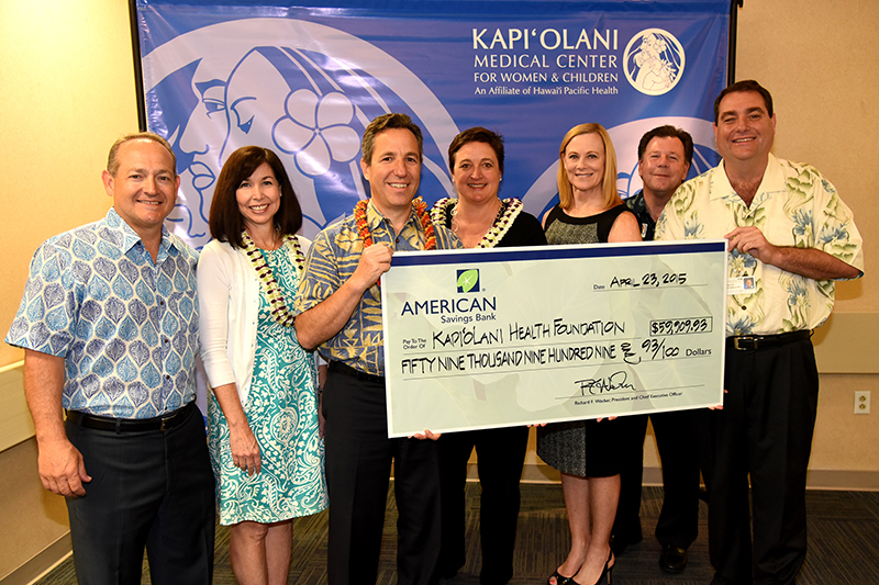 group of people posing for a photo with a large donation check from American Savings Bank for nearly $60000