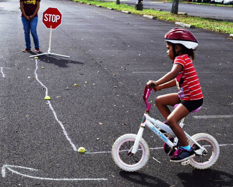 a child on a small bike following a path wearing a helmet