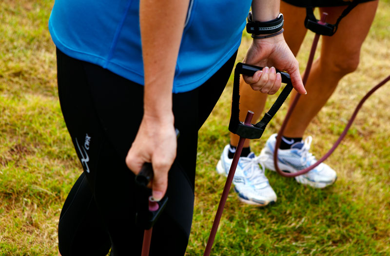 a person on a green field pulling on exercise equipment