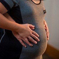 Pregnant woman and her partner toughing mother's belly