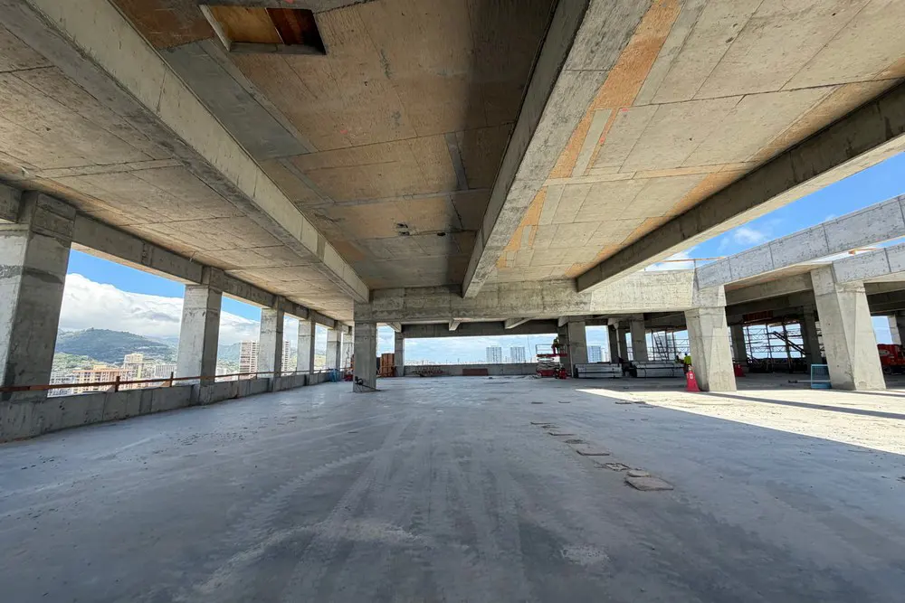 Exposed concrete beams above an open work area on Level 20.