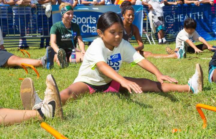 kids sitting on grass doing exercises