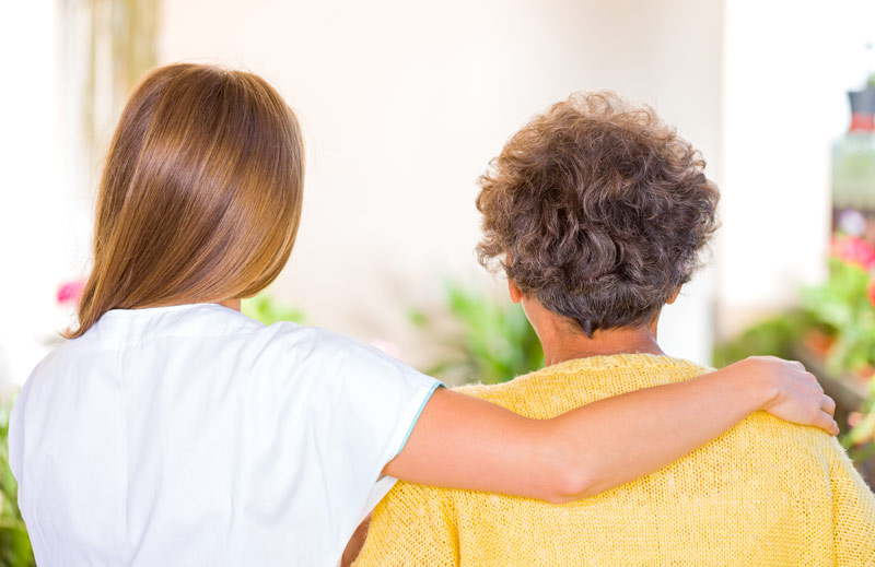 two people with their back to the camera with one person placing an arm around the other