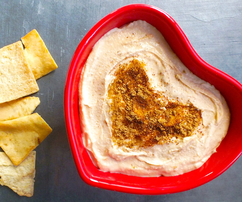 Hummus in a heart-shaped bowl with pita chips