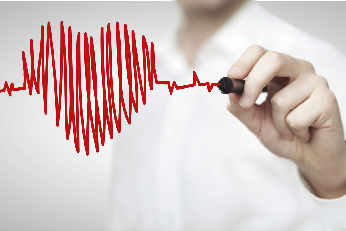 doctor making an illustration of a heart with EKG lines