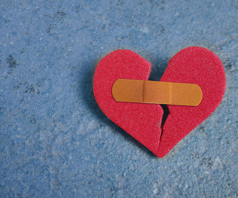 ripped paper heart held together with a band aid