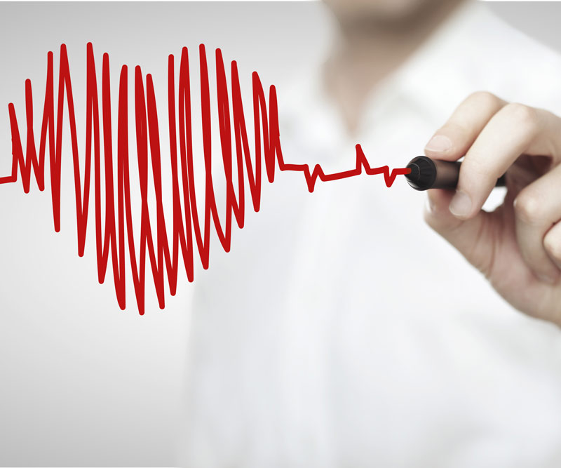 doctor making an illustration of a heart with EKG lines