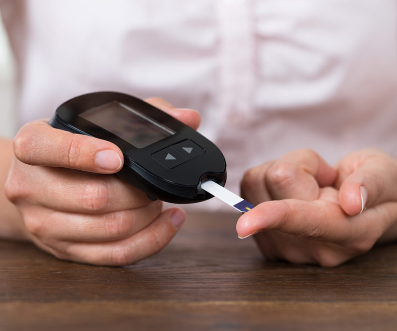 patient testing her blood for diabetes