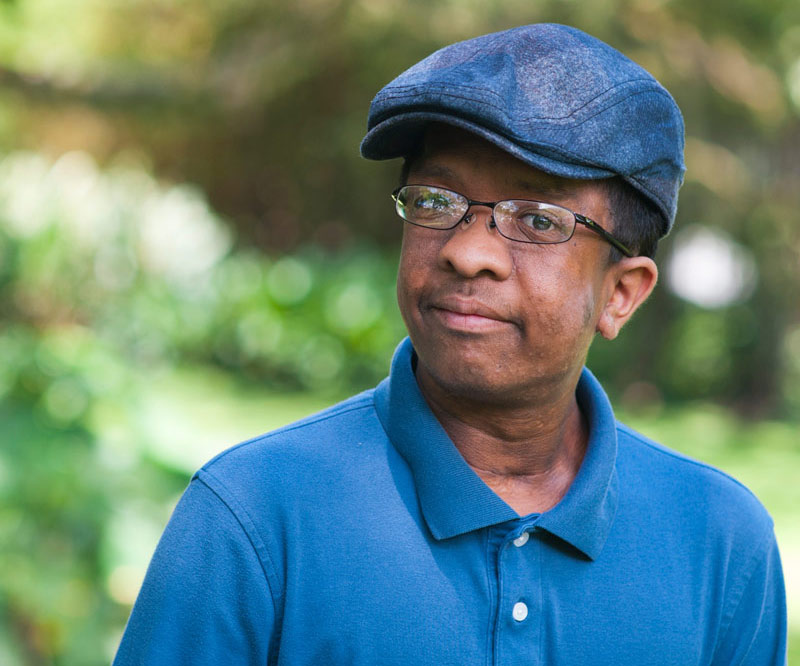 Michael Arakawa wearing blue shirt and blue hat