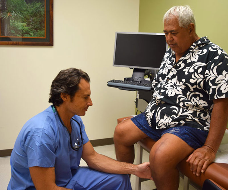 Patient getting his knee examined by doctor