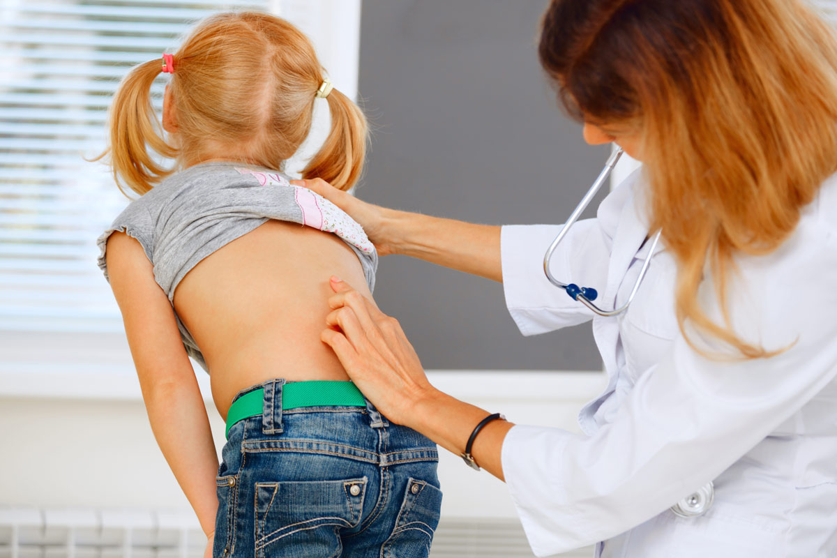 child getting her spine examined by doctor
