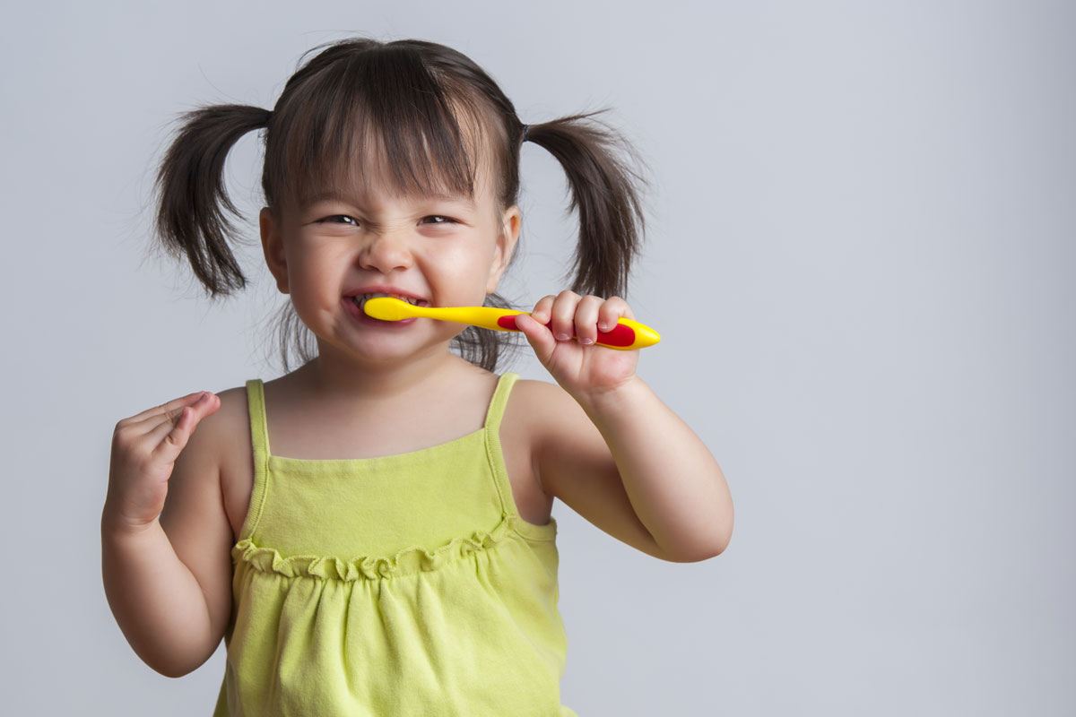 child brushing her teeth