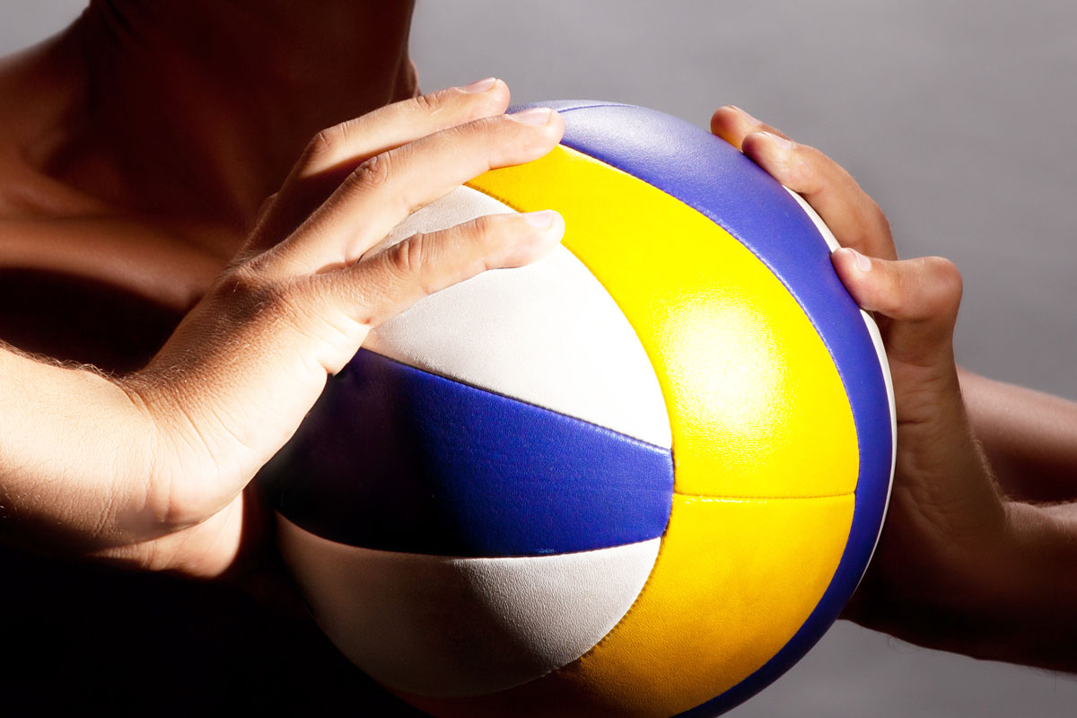 athlete holding a volleyball with both hands