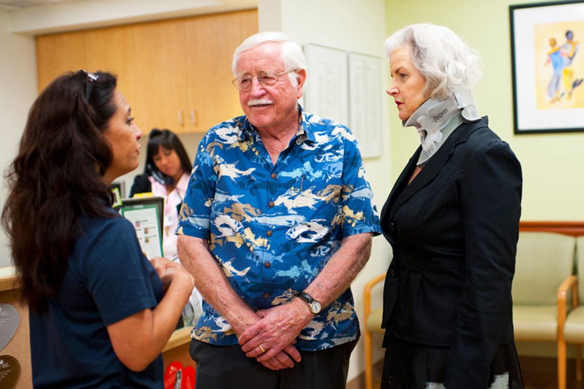 elderly couple speaking with a caretaker