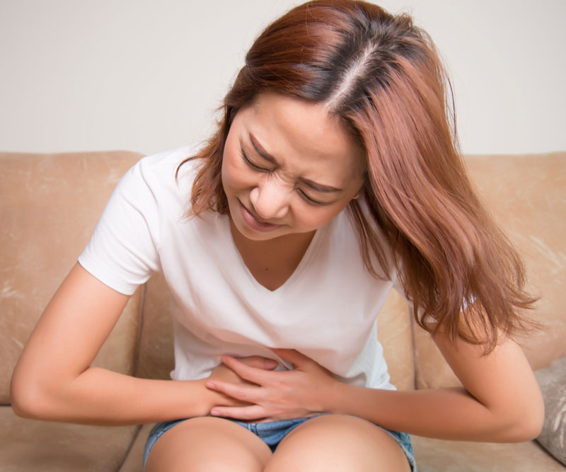woman clutching her sore stomach