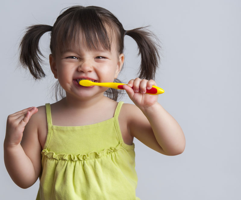 child brushing her teeth