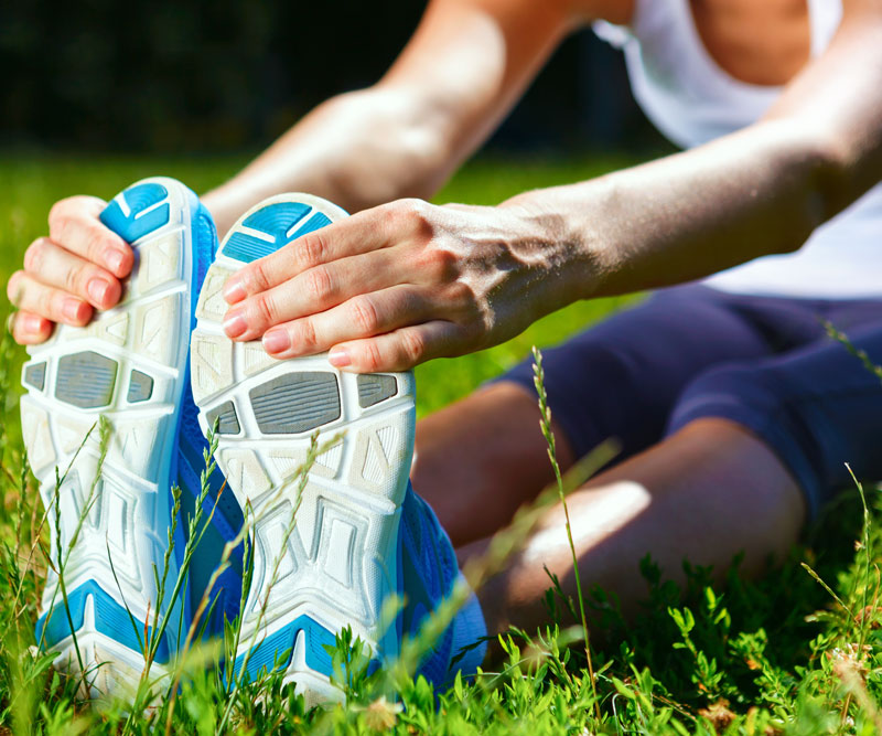 a runner stretching in a grassy field